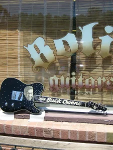 Buck Owens Tele Black infront Bolin Guitars Sign